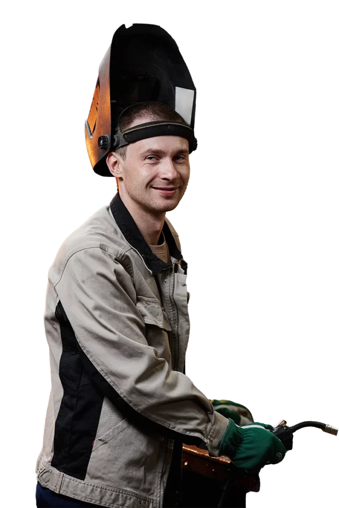 Ein schneidender Schweißer mit Helm und grünen Handschuhen.