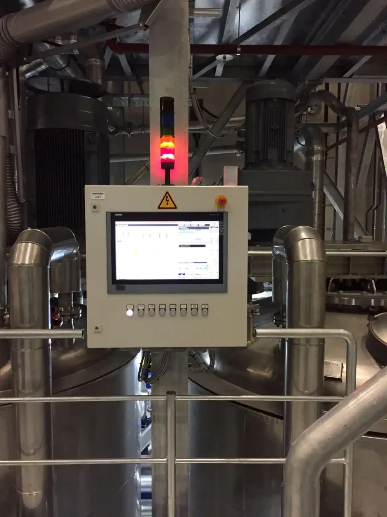 Steuerungsmonitor und Signalleuchte in einer Industrieanlage.